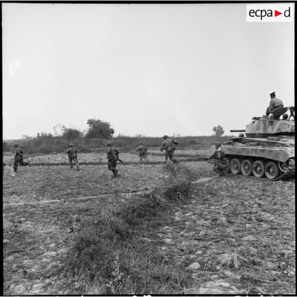 Un char et des soldats dans une plaine