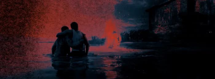 Deux personnages dans l'eau, une maison en flammes derrière eux