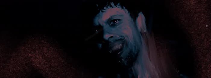 Un visage de vampire, la bouche ouverte, sur fond rouge
