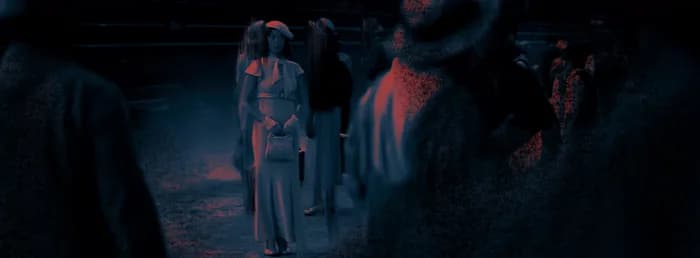 Une file de silhouettes marchant vers une lumière rouge