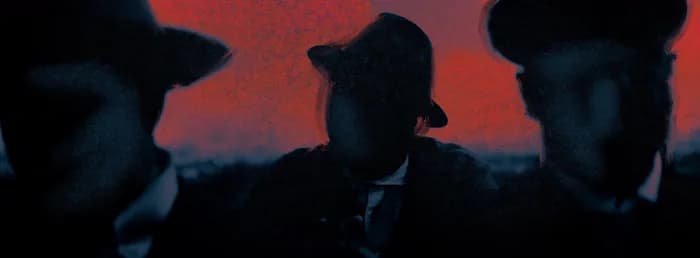 Trois hommes en chapeau devant un ciel rouge